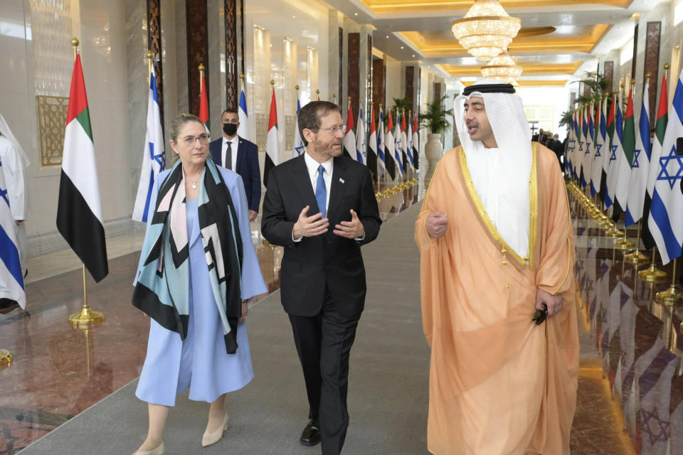 In this photo provided by the Israeli Government Press Office, Israeli President Isaac Herzog, center, and First Lady Michal Herzog are received by UAE Foreign Minister, Sheikh Abdullah bin Zayed Al Nahyan, in Abu Dhabi, United Arab Emirates, Sunday, Jan. 30, 2022. Israel's president arrived in the United Arab Emirates on Sunday in the first official visit by the country's head of state, the latest sign of deepening ties between the two nations as tensions rise in the region. (Amos Ben Gershom/GPO via AP)