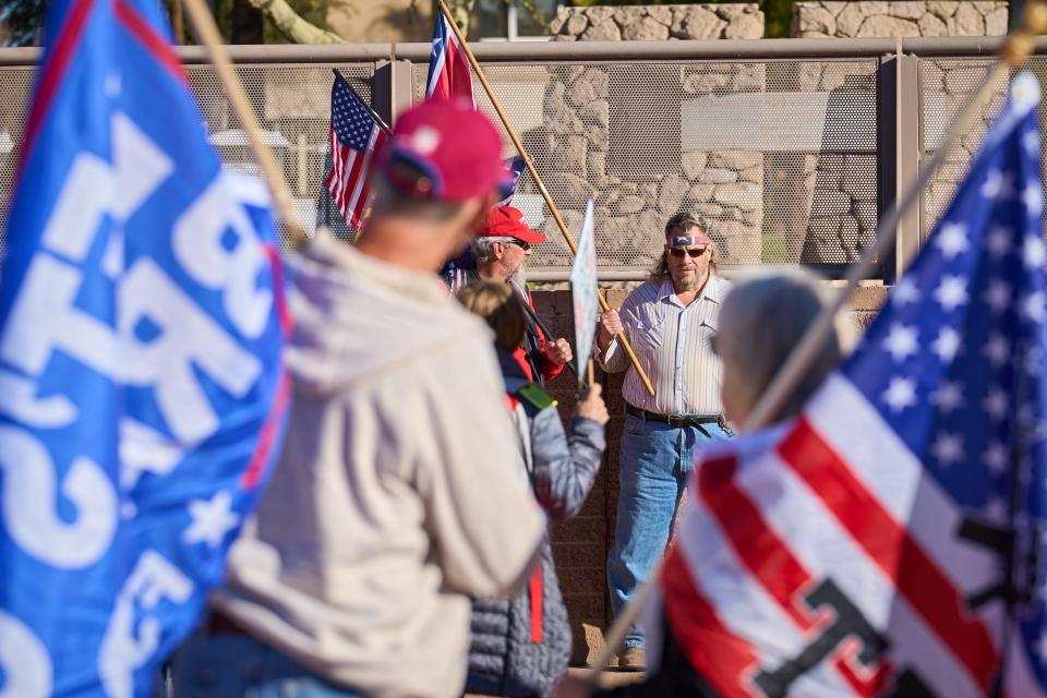 Demonstrators work to block the view of a man carrying a confederate flag as they ask him to leave while they demand a redo of the 2022 general election at Wesley Bolin Memorial Plaza in Phoenix on Friday, Nov 25, 2022.
(Photo: Alex Gould/The Republic)