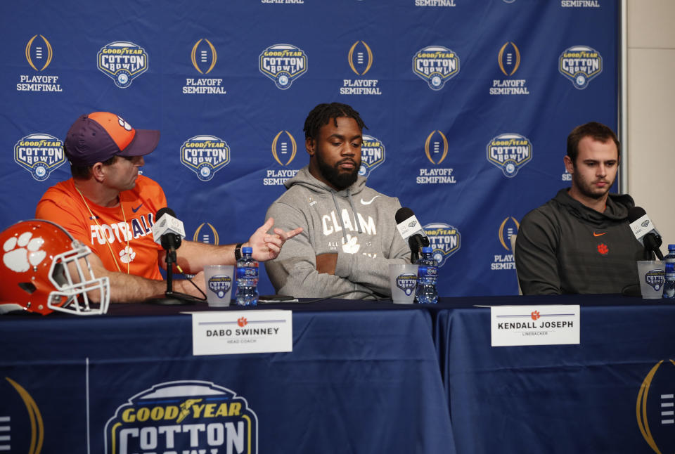 Clemson head coach Dabo Swinney, left, introduces linebacker Kendall Joseph, center, and wide receiver Hunter Renfrow, right, during a news conference at AT&T Stadium in Arlington, Texas, Monday, Dec. 24, 2018. Clemson is scheduled to play Notre Dame in the NCAA Cotton Bowl semi-final playoff Saturday. (AP Photo/Jim Cowsert)