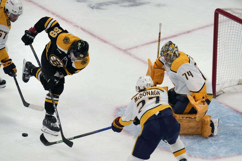 Nashville Predators defenseman Ryan McDonagh (27) knocks the puck away from Boston Bruins left wing Tyler Bertuzzi (59) during the first period of an NHL hockey game Tuesday, March 28, 2023, in Boston. At right is Predators goaltender Juuse Saros. (AP Photo/Charles Krupa)