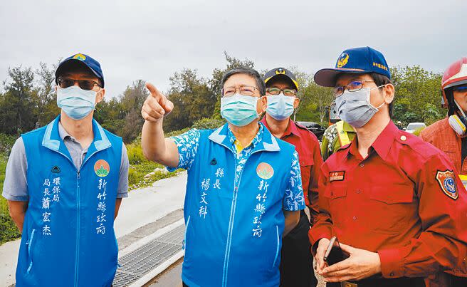 新竹縣新豐垃圾掩埋場發生沼氣引發的自燃火警，6日火勢撲滅後仍處於悶燒狀態，現場調派怪手將堆置垃圾挖開，希望能降溫，避免火勢復燃。縣長楊文科（圖中）到場視察了解。（羅浚濱攝）