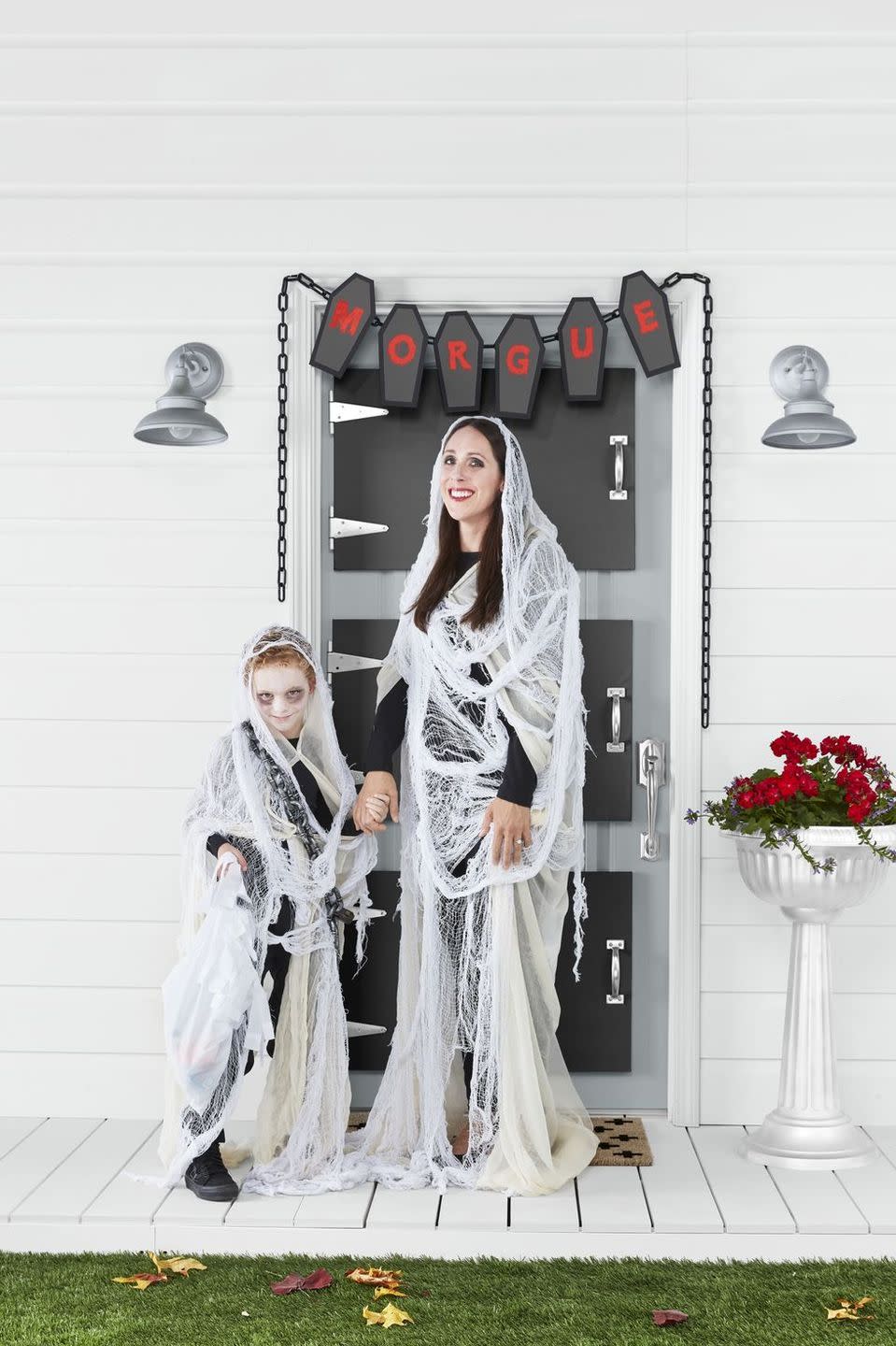 <p>Got cheesecloth and some black eyeshadow? You're halfway to creating these gauzy ghost costumes, which are just the right mix of "scary" and "friendly" to appeal to both kids and their parents. </p><p><strong>Make the Ghost Costumes: </strong>Start with a base layer of black clothing. Paint face with <a href="https://www.amazon.com/Snazaroo-Classic-Face-Paint-White/dp/B000H6W2GW?tag=syn-yahoo-20&ascsubtag=%5Bartid%7C10050.g.23785711%5Bsrc%7Cyahoo-us" rel="nofollow noopener" target="_blank" data-ylk="slk:white face paint;elm:context_link;itc:0;sec:content-canvas" class="link ">white face paint</a> and add <a href="https://www.amazon.com/Alima-Pure-Satin-Matte-Eyeshadow/dp/B07F7DQ1Q8?tag=syn-yahoo-20&ascsubtag=%5Bartid%7C10050.g.23785711%5Bsrc%7Cyahoo-us" rel="nofollow noopener" target="_blank" data-ylk="slk:black eyeshadow;elm:context_link;itc:0;sec:content-canvas" class="link ">black eyeshadow</a> around the eyes. Drape and pin neutral cheesecloth, holding it in place with white safety pins and allowing it to trail on the floor a bit. Add a second layer of large, loosely woven, white gauze—we used door and window decorating material. Drape a plastic chain and vintage-inspired lock around the shoulders.</p><p><a class="link " href="https://www.amazon.com/Good-Cook-Cheesecloth-cotton-White/dp/B000BQKCF6?tag=syn-yahoo-20&ascsubtag=%5Bartid%7C10050.g.23785711%5Bsrc%7Cyahoo-us" rel="nofollow noopener" target="_blank" data-ylk="slk:SHOP CHEESECLOTH;elm:context_link;itc:0;sec:content-canvas">SHOP CHEESECLOTH</a></p>