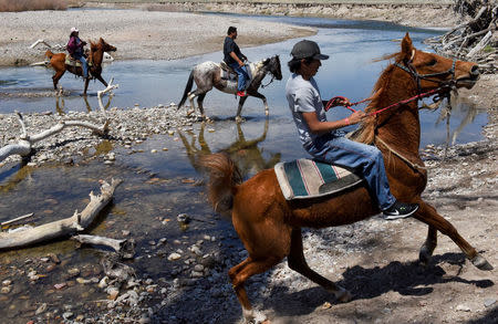 Fort Laramie treaty riders return from crossing a creek in the tribal area on the grounds of the Fort Laramie National Historic Site in Fort Laramie, Wyoming, U.S., April 29, 2018. REUTERS/Stephanie Keith