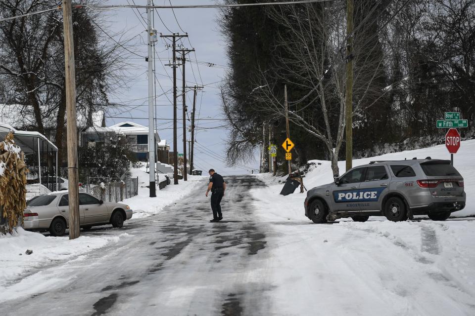 On the fourth day after Knoxville's biggest snowstorm in years, a police officer helps a stranded driver on Boyd Street and West Fifth Avenue.