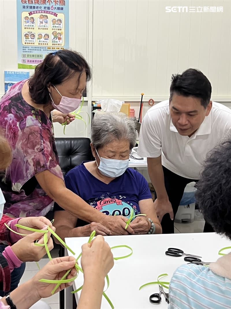 高雄市議員李柏毅照顧長輩已行之有年，彎下身子陪老人家手作。（圖／記者林昱孜攝影）