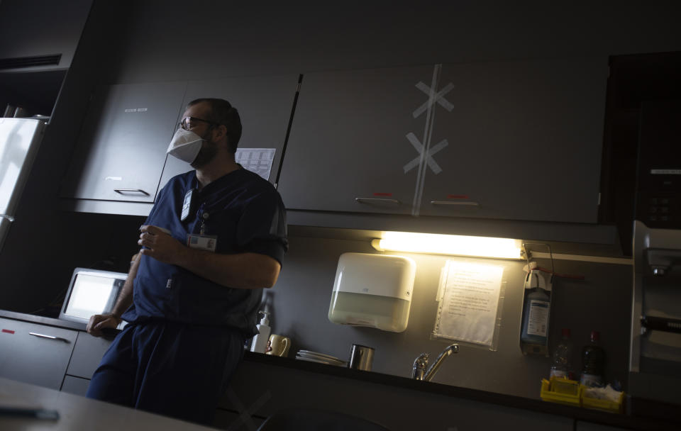 Belgian Army doctor Jent Lievers takes a coffee break prior to attending to COVID-19 patients at the St. Michiel Hospital in Brussels, Tuesday, Nov. 24, 2020. The Belgian military has been called into several hospitals and care homes to alleviate the stress on healthcare personnel. (AP Photo/Virginia Mayo)