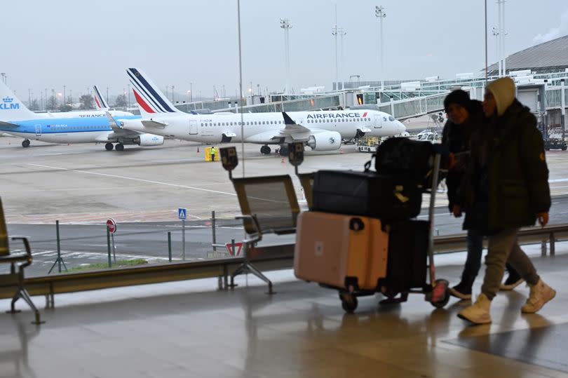 Passengers walk at the Charles de Gaulle Airport near Paris