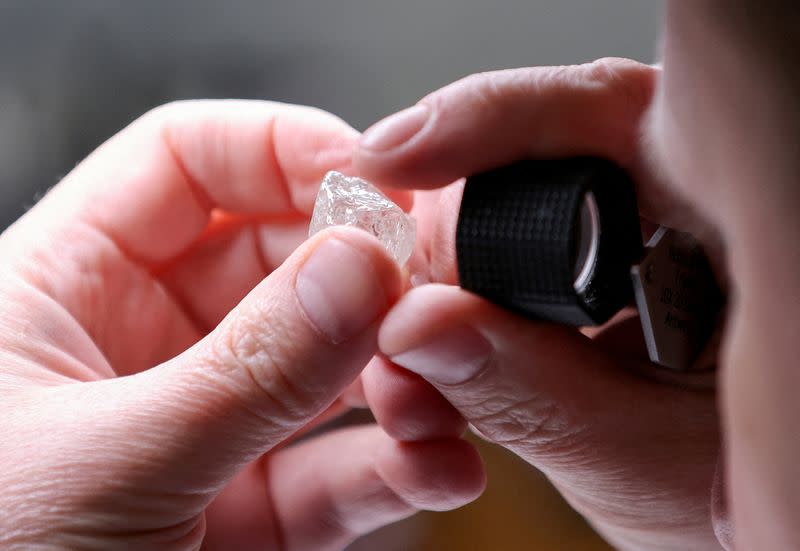 FILE PHOTO: An employee holds a rough diamond at "Diamonds of ALROSA" factory in Moscow