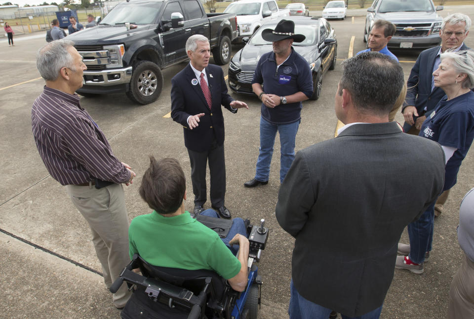 Louisiana gubernatorial candidate Eddie Rispone along with Louisiana U.S. Representative Clay Higgins, and newly elected Louisiana State Senator Mark Abraham, speak with supporters at Chennault International Airport in Lake Charles, La., Monday, Nov. 4, 2019. (Rick Hickman/American Press via AP)