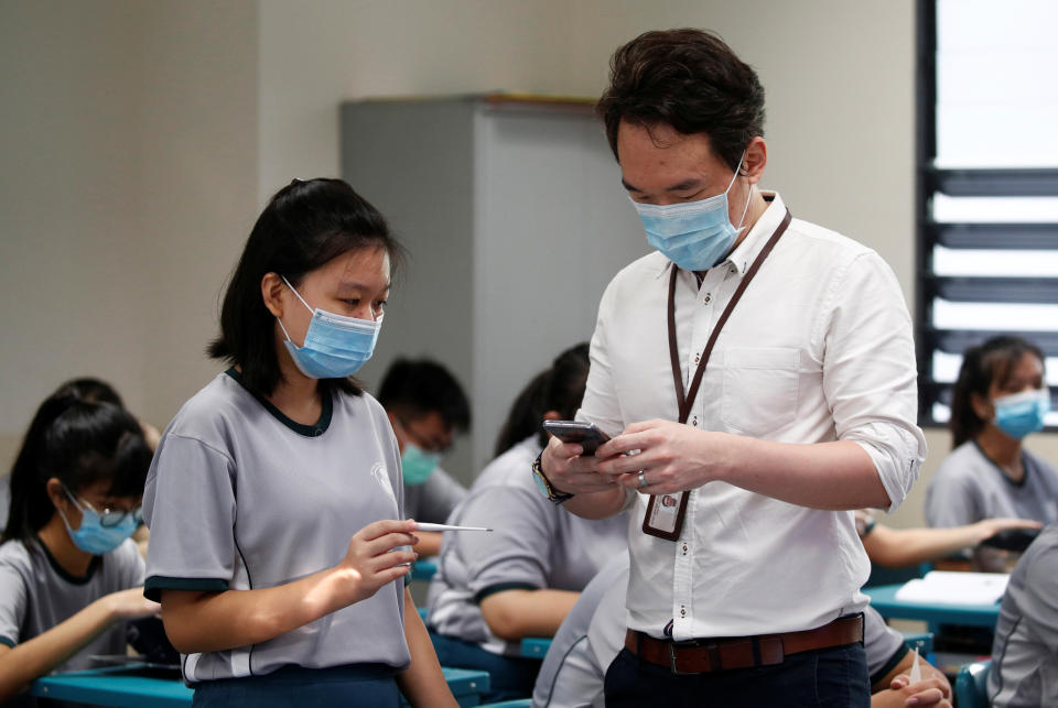 Students have their temperature checked in class at Yio Chu Kang Secondary School, as schools reopen amid the coronavirus disease (COVID-19) outbreak in Singapore June 2, 2020.  REUTERS/Edgar Su