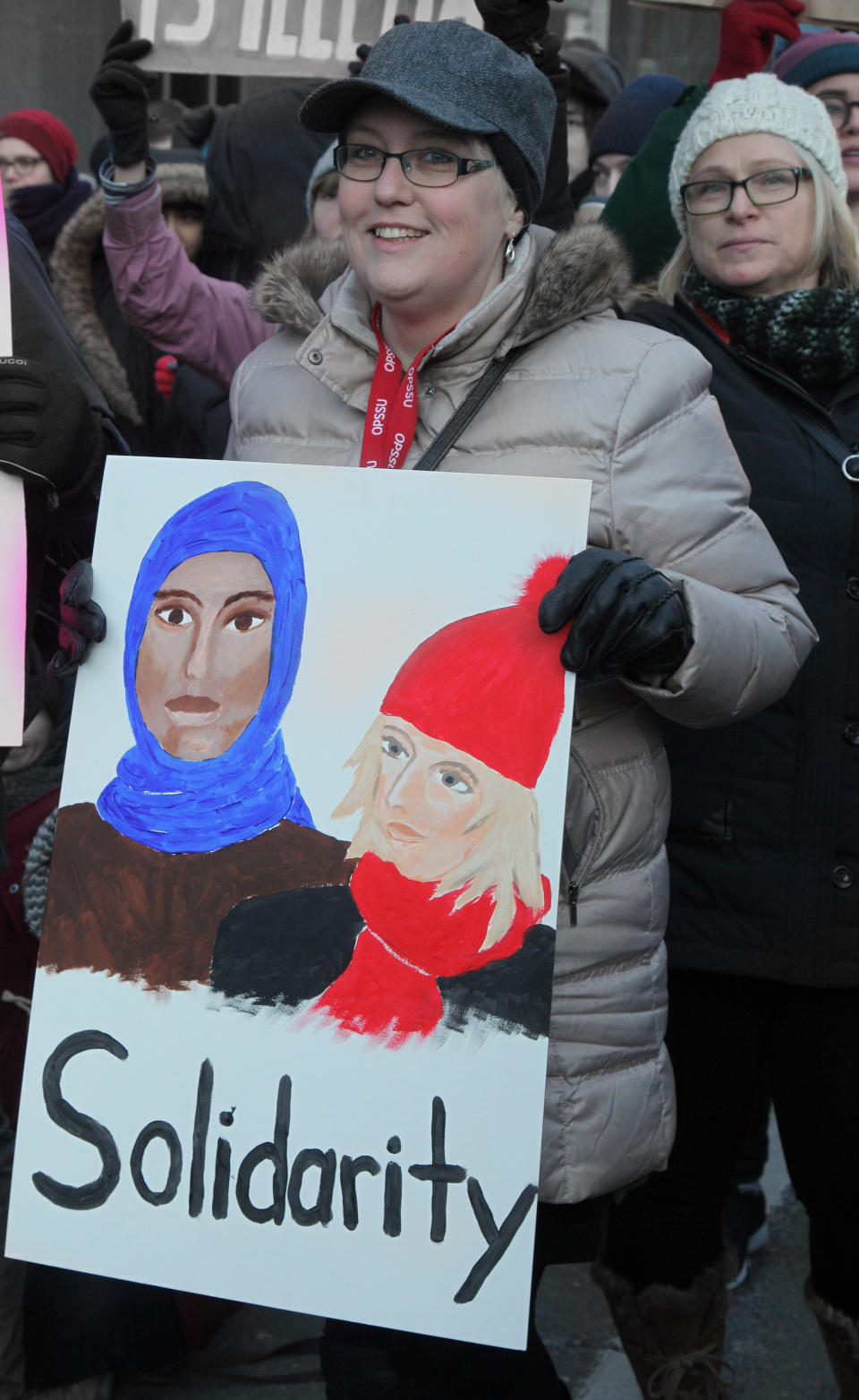 Woman holds a sign depicting a Muslim woman and a Canadian woman with the words 'solidarity' during a massive protest against President Trump's travel ban outside of the U.S. Consulate in downtown Toronto, Ontario, Canada, on January 30, 2017.&nbsp;