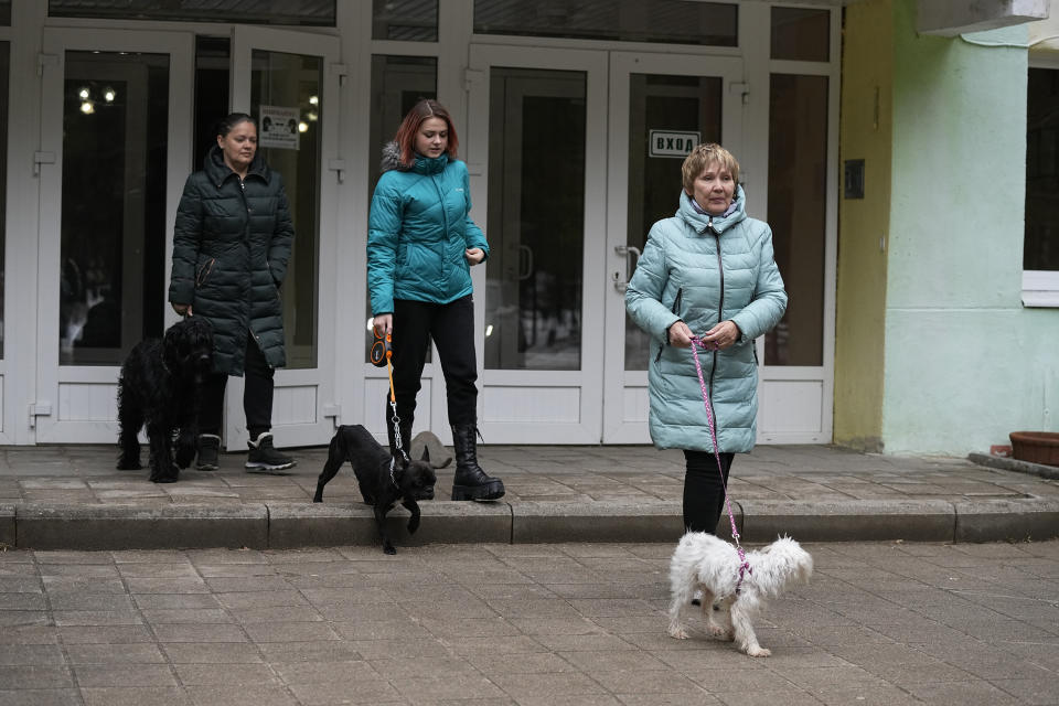 Evacuees from Mariupol, Olga Zabelina, left; her mother, Lyudmila Alfyorova, right, and Maria Bobrushova, stand outside the Sosnovy Bor (Pine Forest) sanatorium near Gavrilov-Yam, Yaroslavl region, Russia, about 240 kilometers (150 miles) northeast of Moscow, on Tuesday, April 12, 2022. Zabelina's family decided one day to get in their car under bomb attacks and run away. "Attacks persisted, shells fell in houses, on people. The only car showed up in our district, I asked them to take me with them. We got in our car as well and left," Zabelina says. (AP Photo/Alexander Zemlianichenko)