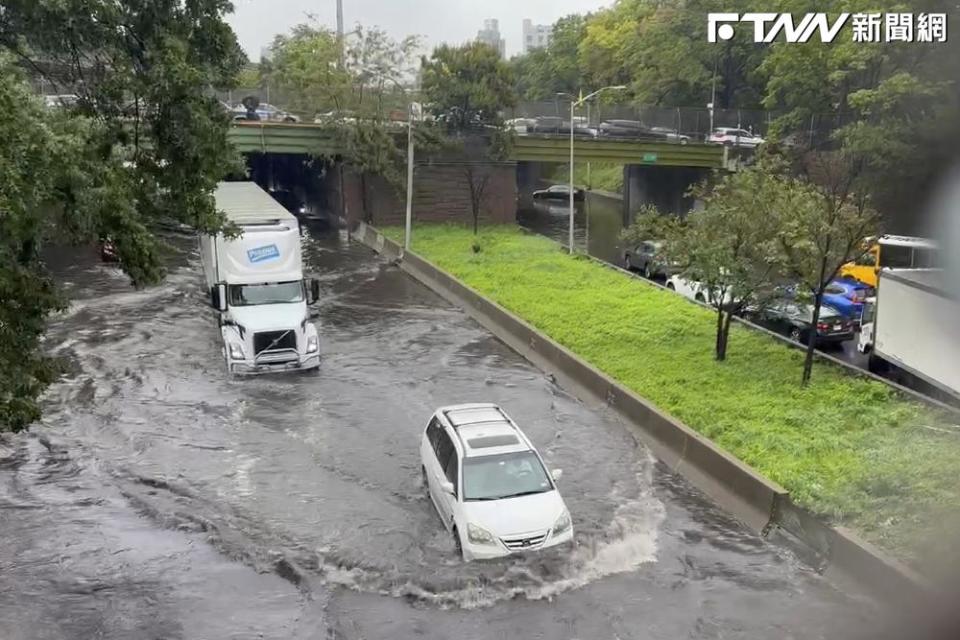 美國紐約市29日降下破紀錄的雨量。圖為水淹郊區道路，民眾在水中行走。（圖／美聯社）