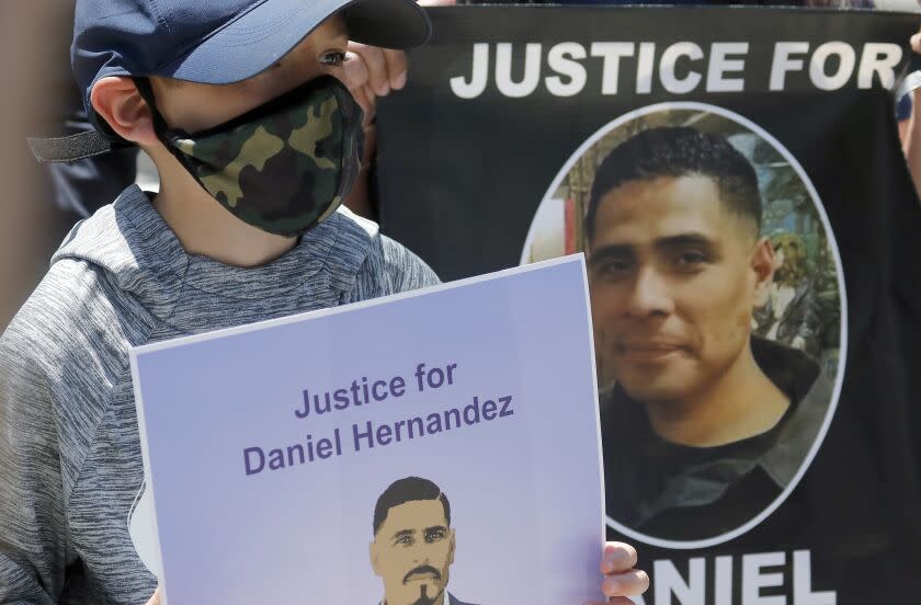 LOS ANGELES, CALIF. - JUNE 26, 2020. Matthew Hernandez, 8, holds a sign with a picture of his uncle, Daniel Hernandez, during a press conference at the L.A. County Hall of Justice on Friday, June 26, 2020. Daniel Hernandez was fatally shot by members of the LAPD in South Los Angeles. The Latino Coialition of Los Angeles is calling for complete and transparent investigations iof officers who have shot and killed Latinos and Blacks. (Luis Sinco/Los Angeles Times)