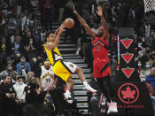 Indiana Pacers guard Malcolm Brogdon (7) passes as Toronto Raptors forward Precious Achiuwa (5) defends during the first half of an NBA basketball game, Wednesday, Oct. 27, 2021 in Toronto. (Nathan Denette/The Canadian Press via AP)