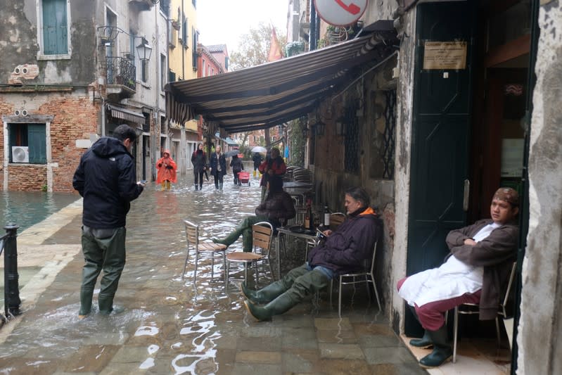 Citizens walk in a flooded street during a period of seasonal high water in Venice