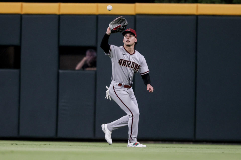 Arizona Diamondbacks center fielder Alek Thomas catches a fly ball for the out on Atlanta Braves' Orlando Arcia during the eighth inning of a baseball game Saturday, July 30, 2022, in Atlanta. (AP Photo/Butch Dill)