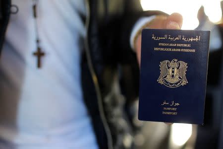 Christian Syrian refugee Ghassan Aleid displays his Syrian passport at a terminal at the Charles-de-Gaulle Airport in Roissy, France, October 2, 2015. REUTERS/Stephane Mahe
