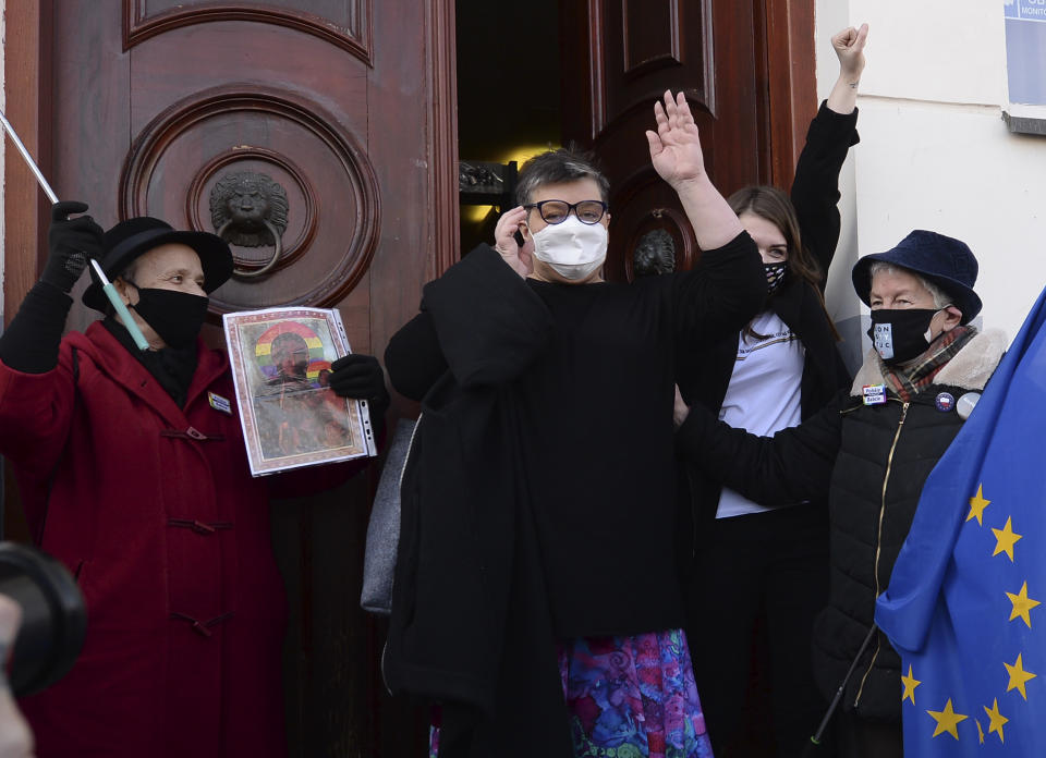 Polish activists Elzbieta Podlesna, center left, and Anna Prus, center right, surround by supporters as they leave court after being acquitted of desecration by a court in Plock, Poland, Tuesday March 2, 2021. A Polish court has acquitted three activists who had been accused of desecration for adding the LGBT rainbow to images of a revered Roman Catholic icon. In posters that they put up in protest in their city of Plock, the activists used the rainbow in place of halos on a revered image of the Virgin Mary and baby Jesus. (AP Photo/Czarek Sokolowski)