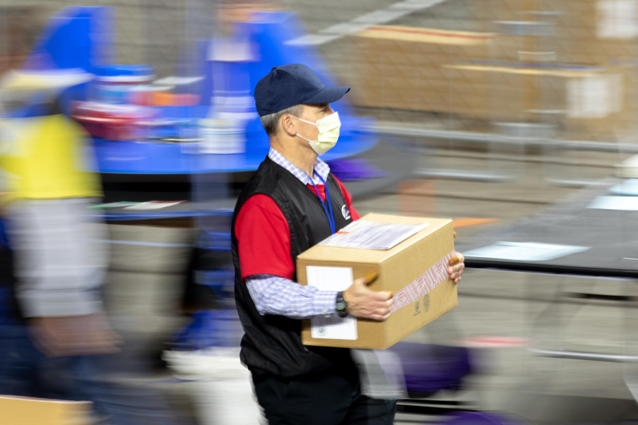 A contractor working for Cyber Ninjas, who was hired by the Arizona State Senate transports ballots from the 2020 general election at Veterans Memorial Coliseum on May 1, 2021 in Phoenix, Arizona.(Courtney Pedroza/Getty Images)