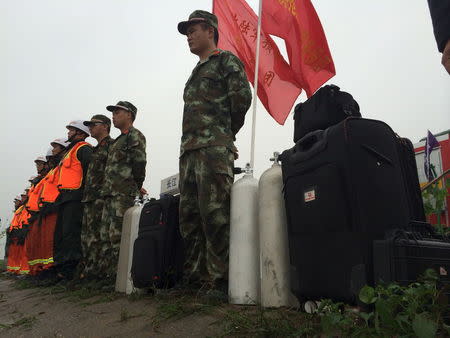 Rescue workers stand near the site where a ship sank, in the Jianli section of the Yangtze River, Hubei province, China, June 2, 2015. REUTERS/Chen Zhuo/Yangzi River Daily