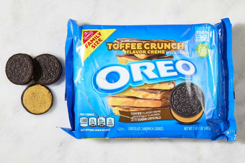 overhead shot of a box of fudge covered oreos, with a full and some toffee crunch oreos to the left of the box