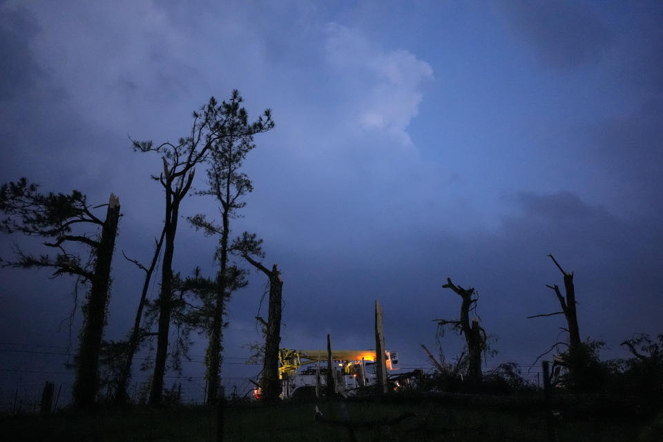 A utility truck passes damaged trees along Cothran Road, after severe storms tore through the area, Wednesday, May 8, 2024, in Columbia, Tenn. (AP Photo/George Walker IV)
