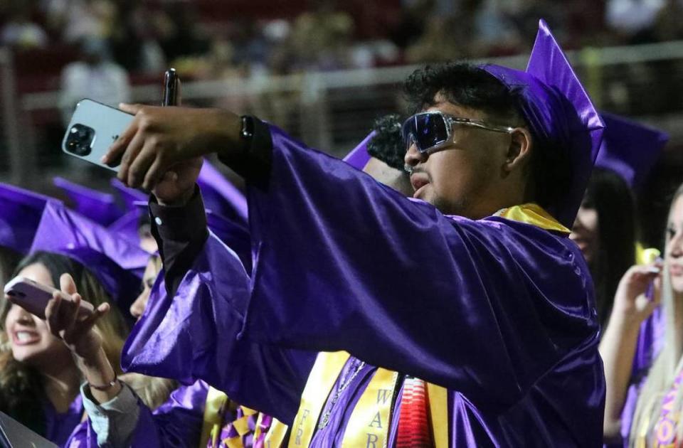 A graduate snaps a selfie during the Fresno High graduation ceremony held at the Save Mart Center on June 5, 2023.