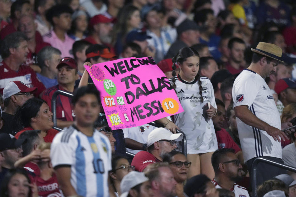 Fans hold up a sign about Lionel Messi during the first half of a Leagues Cup soccer match between Inter Miami and FC Dallas on Sunday, Aug. 6, 2023, in Frisco, Texas. (AP Photo/LM Otero)