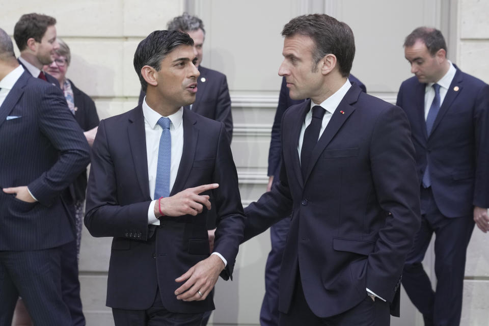 French President Emmanuel Macron, centre right, and Britain's Prime Minister Rishi Sunak, centre left, talk after a group picture with ministers during a French-British summit at the Elysee Palace in Paris, Friday, March 10, 2023. French President Emmanuel Macron and British Prime Minister Rishi Sunak meet for a summit aimed at mending relations following post-Brexit tensions, as well as improving military and business ties and toughening efforts against Channel migrant crossings. (AP Photo/Kin Cheung, Pool)