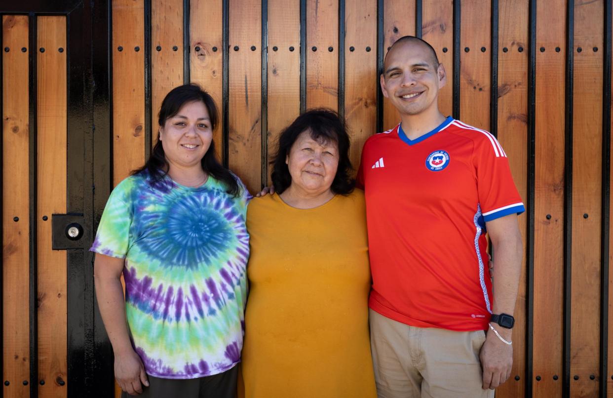 <span>Sean and Emily with their birth mother, Sara, outside her house in Santiago.</span><span>Photograph: Sofía Yanjarí/The Guardian</span>