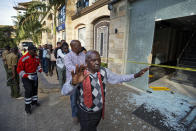 A civilian holds his hands in the air as he and others flee at a hotel complex in Nairobi, Kenya Tuesday, Jan. 15, 2019. Terrorists attacked an upscale hotel complex in Kenya's capital Tuesday, sending people fleeing in panic as explosions and heavy gunfire reverberated through the neighborhood. (AP Photo/Ben Curtis)