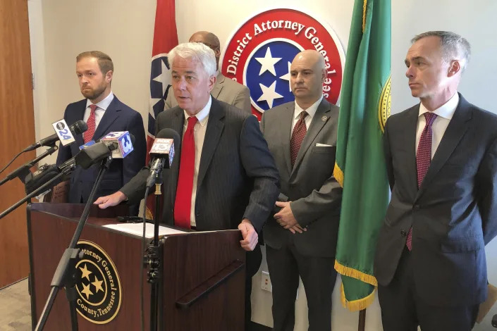 Shelby County District Attorney Steve Mulroy, at lectern, speaks with reporters during a news conference in Memphis, Tenn., on Monday, March 27, 2023, announcing that his office will seek the death penalty if Ezekiel Kelly is convicted of first-degree murder in a daylong shooting rampage that left three people dead and three others wounded. (AP Photo/Adrian Sainz)