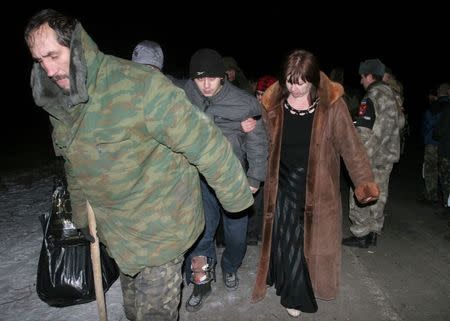 Members of pro-Russian separatists (L and C) walk after being exchanged for Ukrainian prisoners of war near the village of Zholobok in Luhansk region, eastern Ukraine, February 21, 2015. REUTERS/Igor Tkachenko