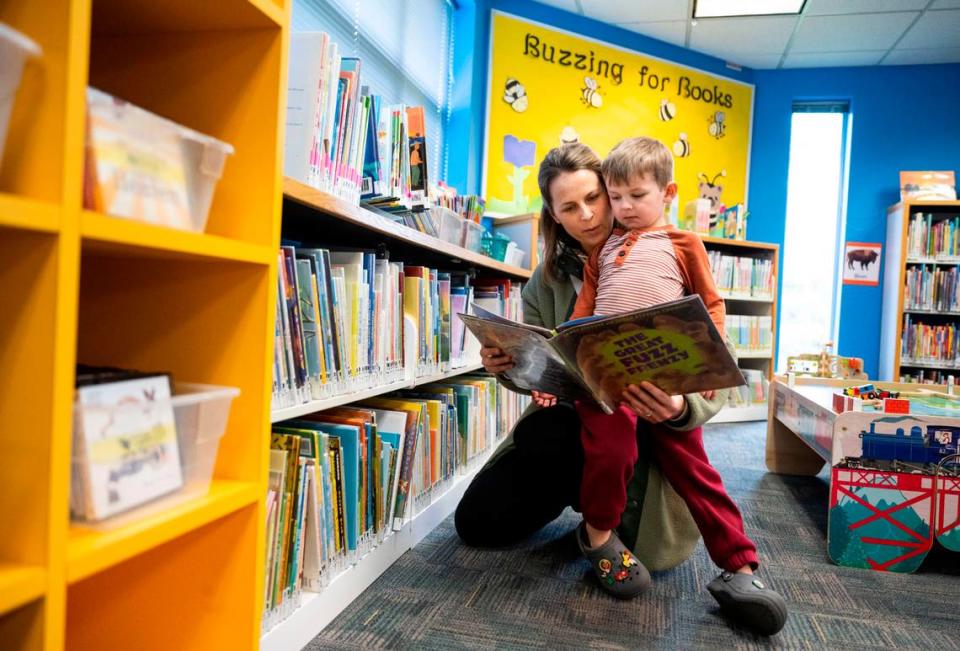 Rachel Oberg reads a book to her son, Maverick Oberg, 5, in the children’s reading area of the Sumner Public Library on Fryar Avenue in Sumner, Wash. on March 23, 2023. Sumner City Council and the Pierce County Libraries board of trustees passed resolutions to place a bond measure on the primary ballet in August that would raise funds for a new library branch.