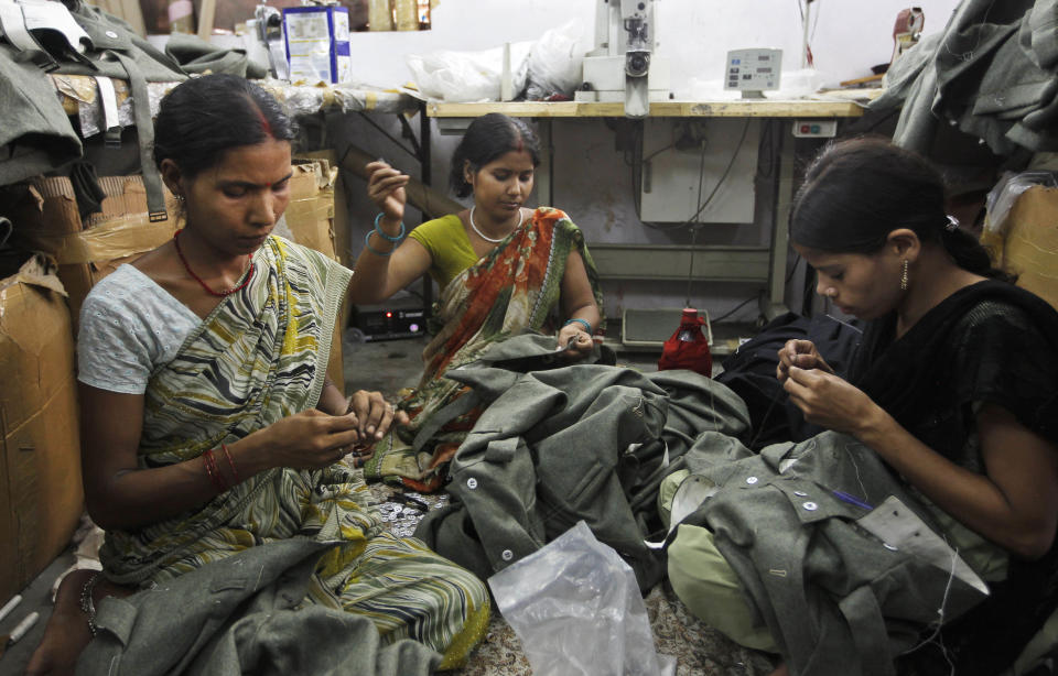 In this, June 2, 2012 photograph, workers sew dresses being prepared for a reenactment of World war II at a workshop owned by Indian businessman Ashok Rai, unseen, in Sahibabad, India. From Hollywood war movies to Japanese Samurai films to battle re-enactments across Europe, Rai is one of the world's go-to men for historic weapons and battle attire. (AP Photo/Saurabh Das)