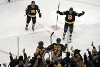 Boston Bruins defenseman Charlie McAvoy (73) is congratulated by teammates at the glass as fans cheer after he scored the winning goal past Washington Capitals goaltender Vitek Vanecek late in the third period of an NHL hockey game, Thursday, Jan. 20, 2022, in Boston. (AP Photo/Mary Schwalm)