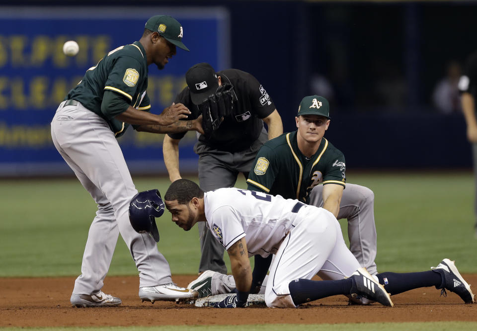 Tampa Bay Rays' Tommy Pham, center, slides into second base with a double as the ball gets away from Oakland Athletics pitcher Edwin Jackson, left, and third baseman Matt Chapman, right, during the fourth inning of a baseball game Friday, Sept. 14, 2018, in St. Petersburg, Fla. (AP Photo/Chris O'Meara)