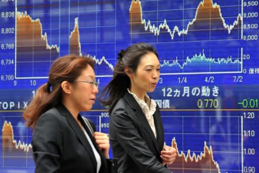 Pedestrians pass a share prices board in Tokyo. Asian markets mostly rose Thursday following upbeat earnings results in the region and the United States, while eurozone fears eased slightly on hopes over the funding of future bailouts