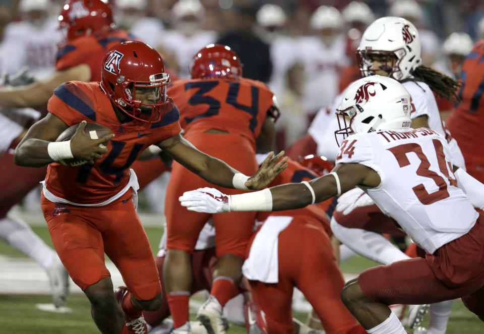 Arizona quarterback Khalil Tate (14) stiff-arms Washington State safety Jalen Thompson (34) in the first half during an NCAA college football game, Saturday, Oct. 28, 2017, in Tucson, Ariz. (AP Photo/Rick Scuteri)