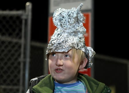 A boy wears a tinfoil hat at the gates of Area 51 as an influx of tourists responding to a call to 'storm' Area 51, a secretive U.S. military base believed by UFO enthusiasts to hold government secrets about extra-terrestrials, is expected in Rachel