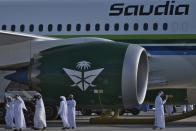 Emiratis walk past a Saudia Boeing 787 Dreamliner with a retro logo design at the Dubai Air Show in Dubai, United Arab Emirates, Monday, Nov. 13, 2023. Long-haul carrier Emirates opened the Dubai Air Show with a $52 billion purchase of Boeing Co. aircraft, showing how aviation has bounced back after the groundings of the coronavirus pandemic, even as Israel's war with Hamas clouds regional security. (AP Photo/Jon Gambrell)