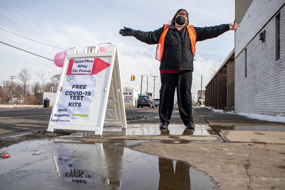 Librarian JoAnn Mannino guides cars to pick up free COVID-19 tests at the Detroit Public Library Wilder Branch in Detroit on Feb. 2, 2022. Visitors received up to five free at-home COVID-19 test kits from the state health department via the library.