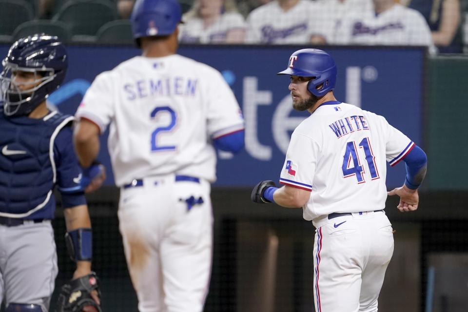 Tampa Bay Rays catcher Francisco Mejia, left, stands by the plate as Texas Rangers' Marcus Semien (2) and Eli White (41) score on a Mitch Garver double in the sixth inning of a baseball game, Monday, May 30, 2022, in Arlington, Texas. (AP Photo/Tony Gutierrez)