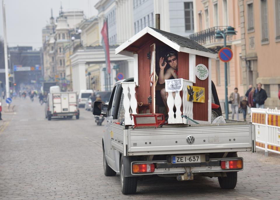 In this May 10, 2013 photo, a man waves from a mobile sauna by the Market Square in Helsinki, Finland. . Invented by the Finns, saunas are source of national pride and most private homes have them. (AP Photo/Pekka Sakki, Lehtikuva) FINLAND OUT