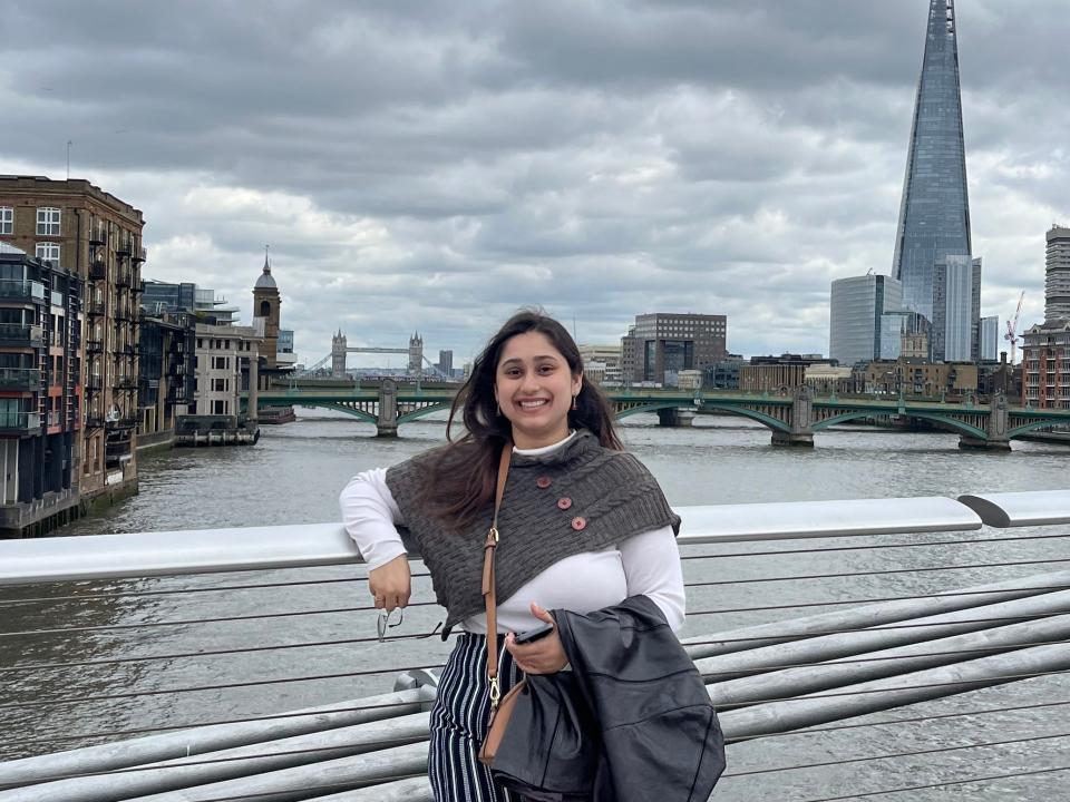 Varisha Tariq smiling and standing on a bridge on a cloudy day.