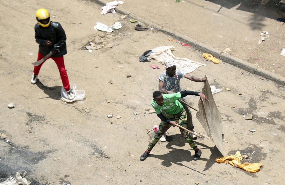 Nubian community residents hold wooden shields and a machete after fight broke out among Leo and Nubi community during a mass rally called by the opposition leader Raila Odinga over the high cost of living in Kibera Slums, Nairobi, Monday, March 27, 2023. Police in Kenya are on high alert ahead of the second round of anti-government protests organized by the opposition that has been termed as illegal by the government. Police chief Japheth Koome insists that Monday's protests are illegal but the opposition leader Raila Odinga says Kenyans have a right to demonstrate.(AP Photo/Brian Inganga)