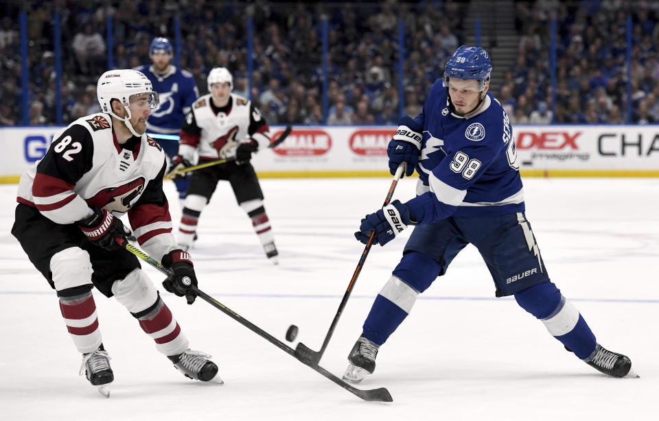 Arizona Coyotes defenseman Jordan Oesterle (82) stops a shot from Tampa Bay Lightning defenseman Mikhail Sergachev (98) during the second period of an NHL hockey game Monday, March 18, 2019, in Tampa, Fla. (AP Photo/Jason Behnken)