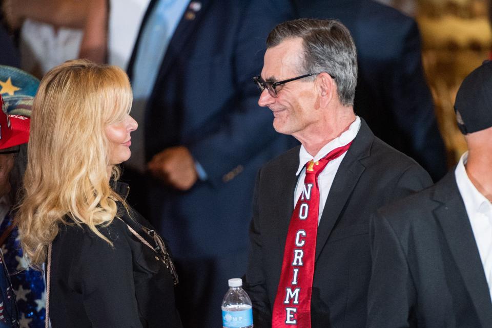 A guest wears a tie with the words "No Crime," written on it while waiting in the Mar-A-Lago main ballroom before the start of a press event at Mar-A-Lago on Tuesday, April 4, 2023, in Palm Beach FL. Former President Donald Trump returned to Mar-A-Lago Tuesday evening after facing arraignment in New York earlier in the day.