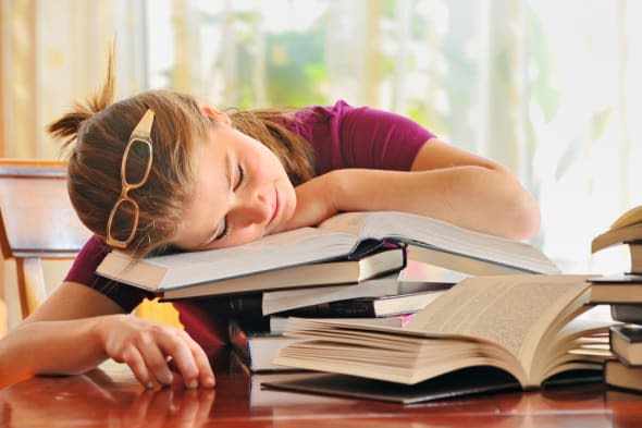 teenager girl sleeping on books